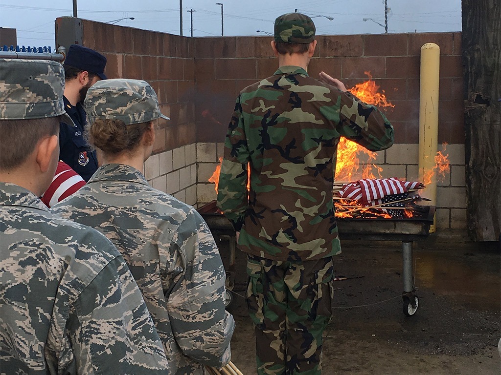 Civil air patrol cadets performing a flag retirement ceremony.