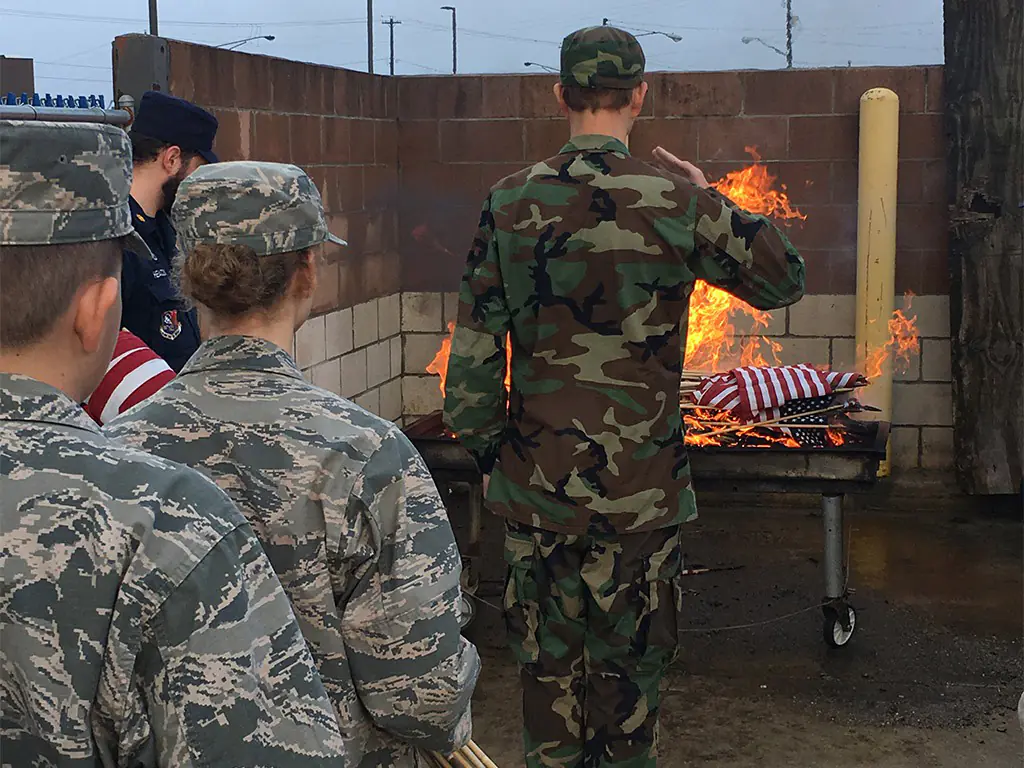 Civil air patrol cadets performing a flag retirement ceremony.
