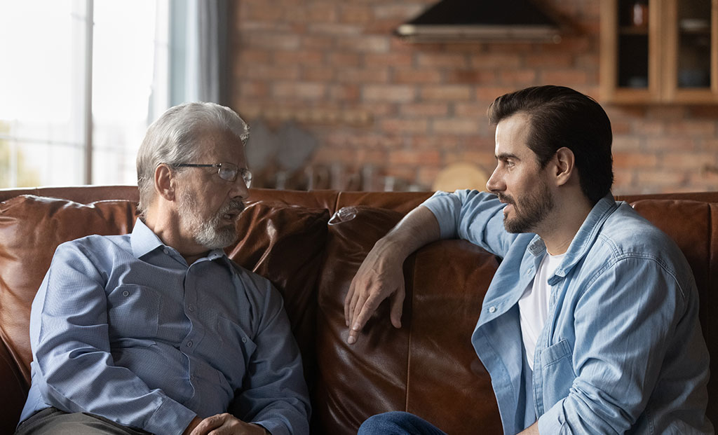 Two men having a conversation on a couch