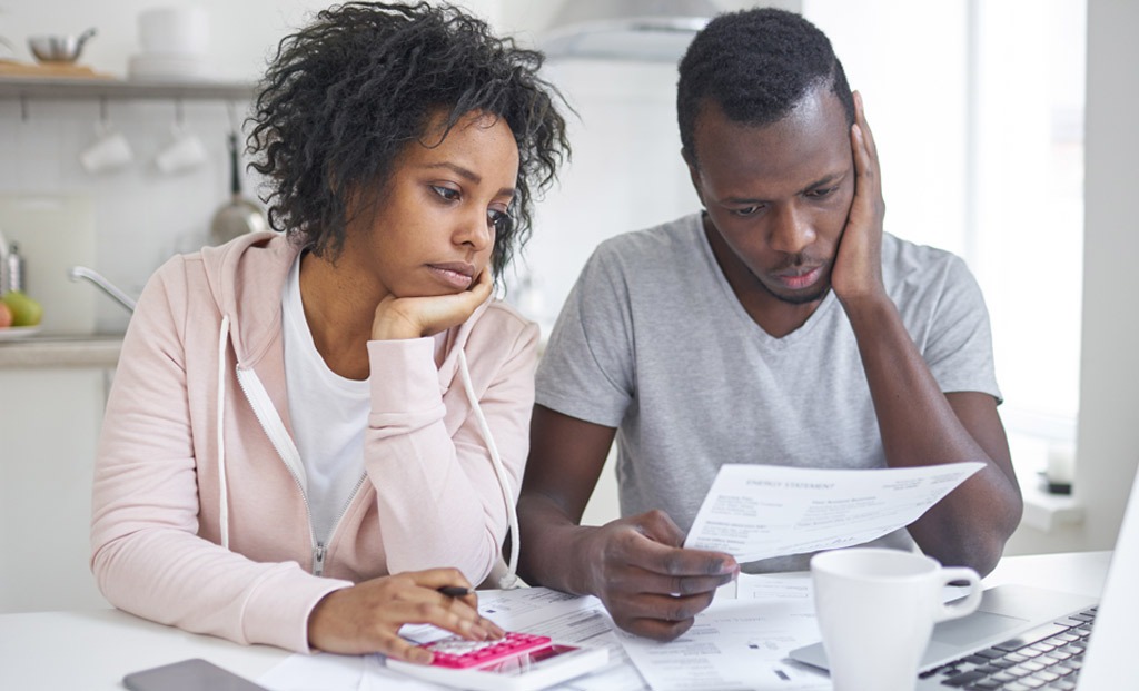 Couple reviews bills at a table.