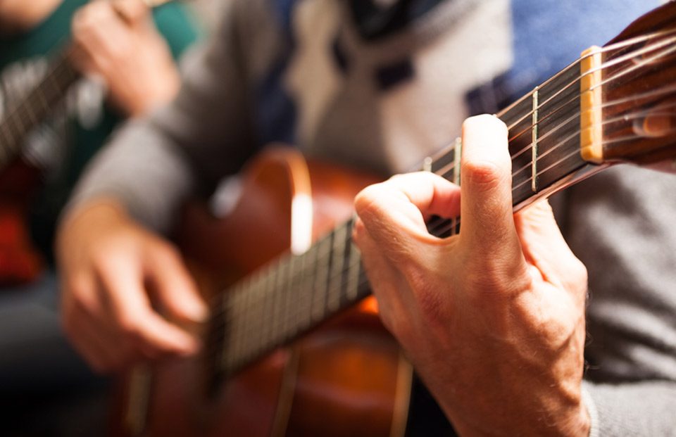 Closeup of a hands playing a guitar.