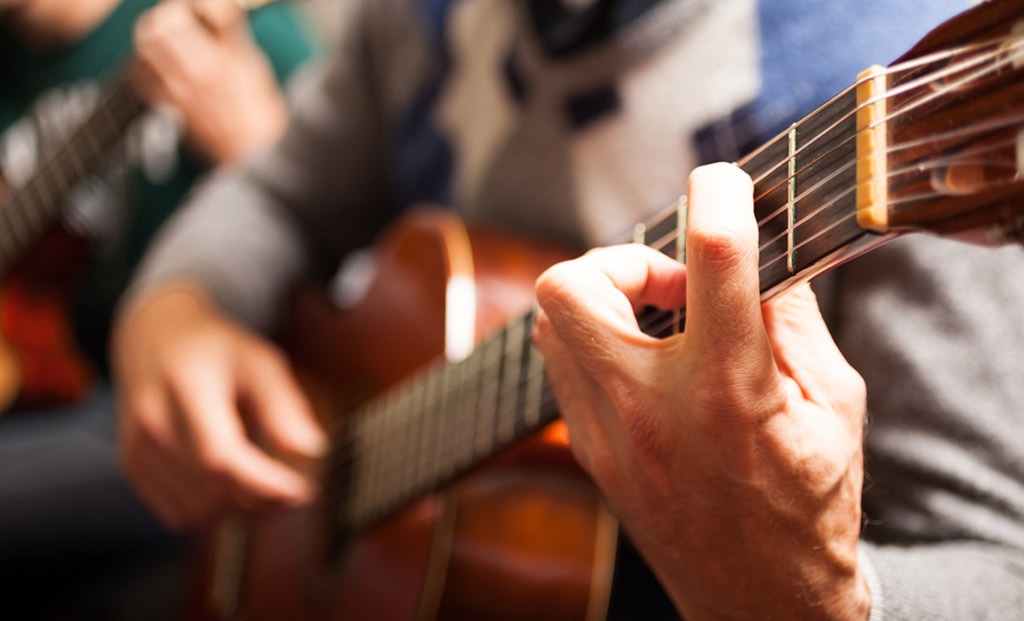 Closeup of a hands playing a guitar.