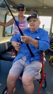 Andy Hocevar reeling a fishing rod from his chair on a boat.