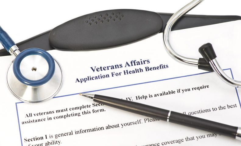 Clipboard with application for VA Health Benefits.