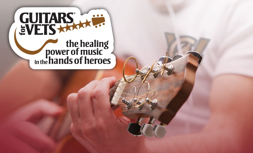 Guitars for Vets logo overtop a man strumming a guitar.