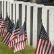 American flags in front of row of gravestones
