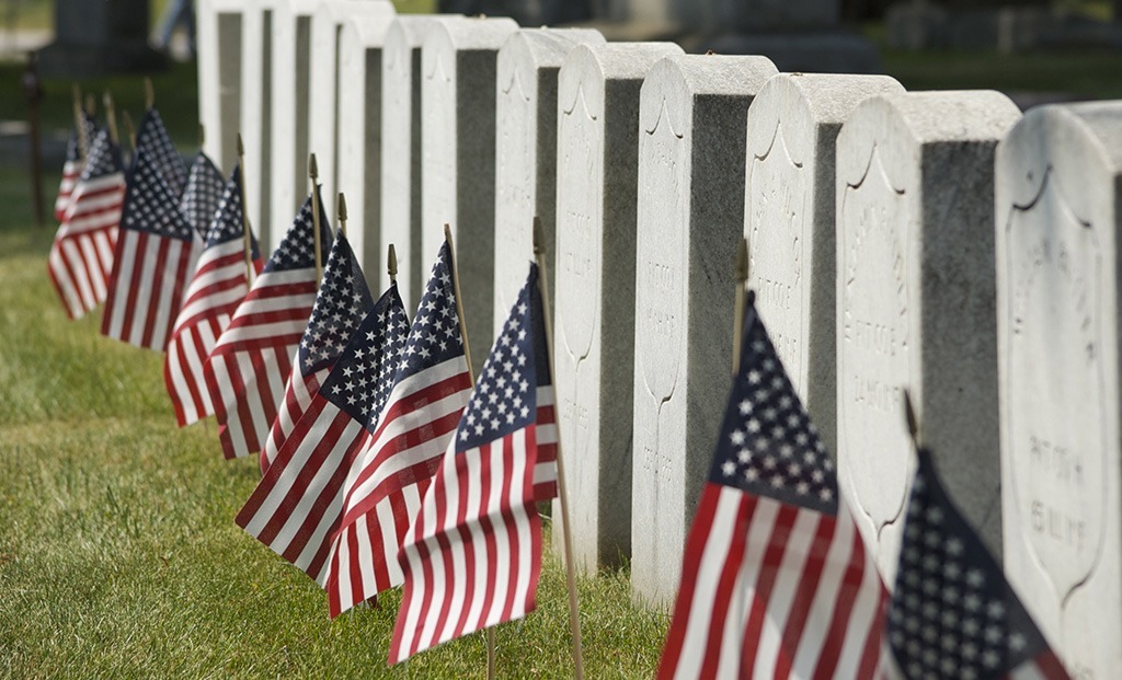 American flags in front of row of gravestones