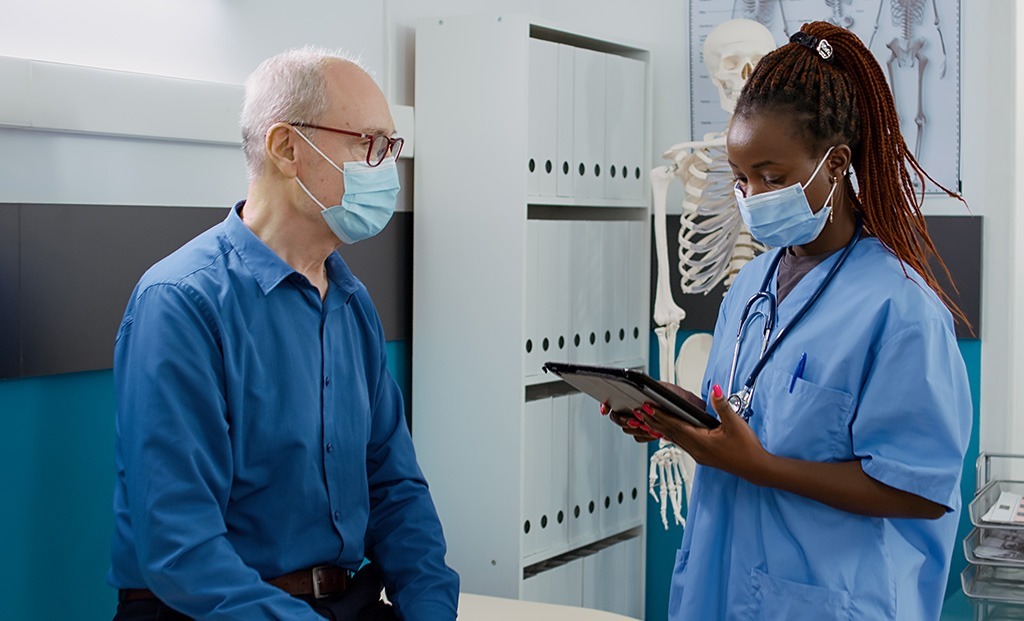 Dr talking to older man in a urgent care room