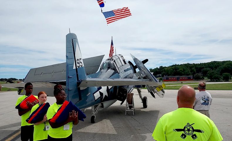 American flag overtop a plane at the 2022 Props and Pistons Festival