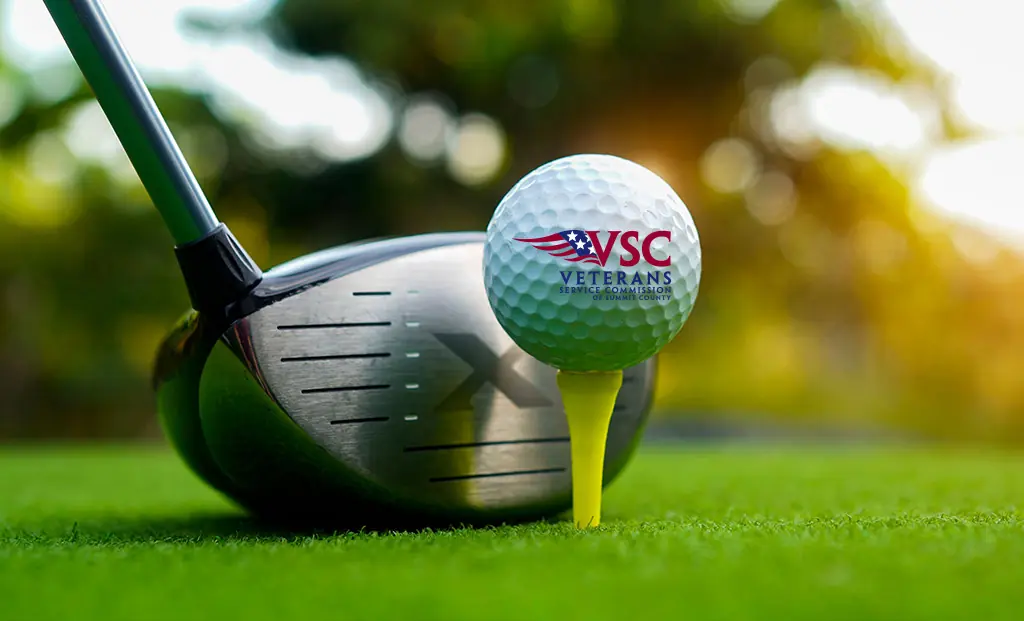 VSC Golf ball on a tee about to be hit by a golf club driver head.